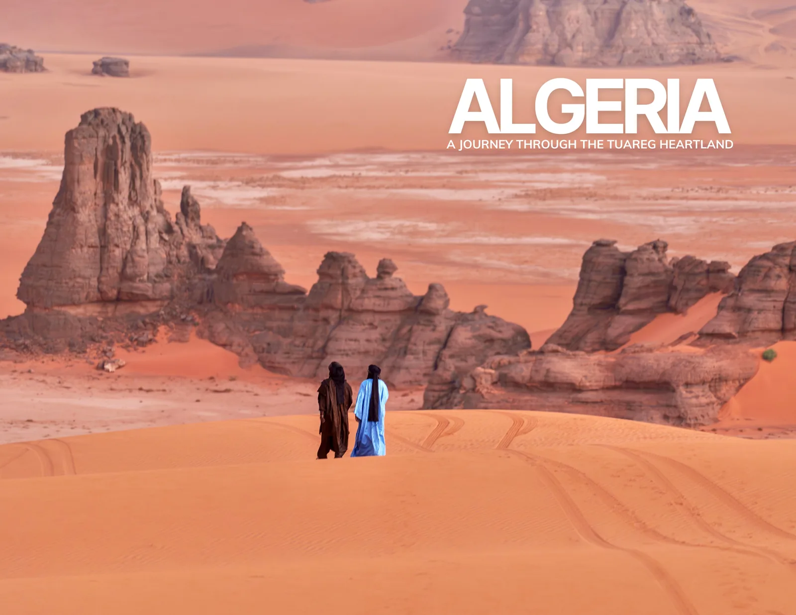 Cover of the photobook Algeria: A Journey Through the Tuareg Heartland, two figures walking toward sandstone towers in the Sahara.