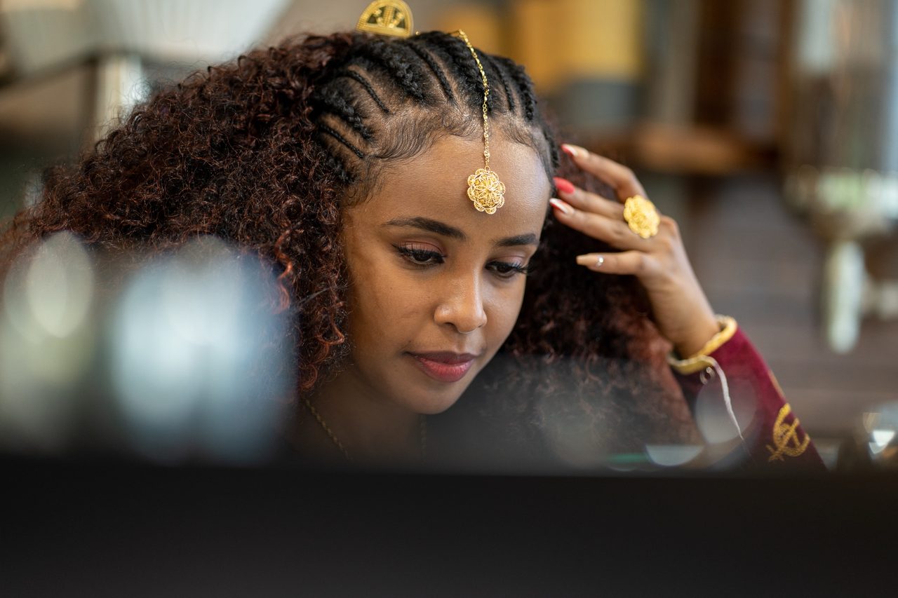 Portrait of a woman in traditional jewellery with braided hair in a café